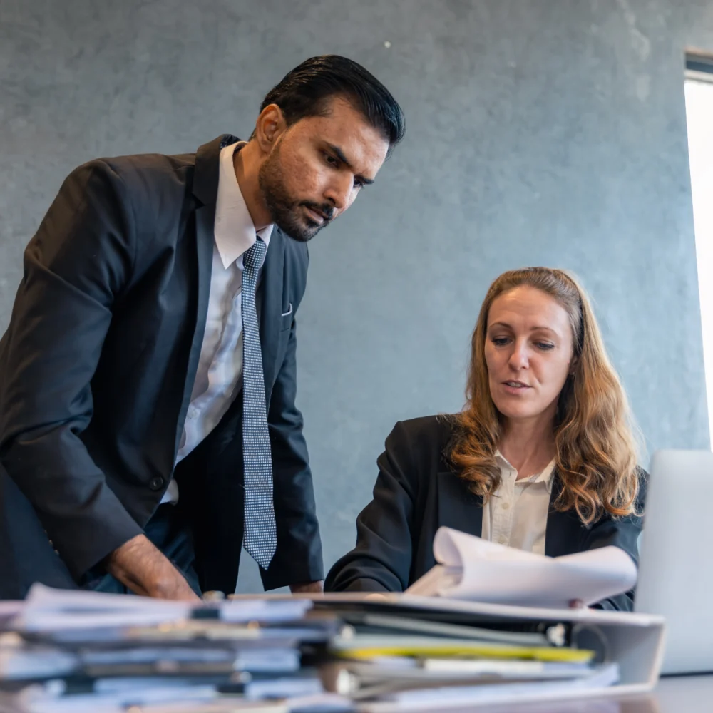 business-colleagues-reviewing-documents-and-laptop-2024-12-07-23-33-11-utc